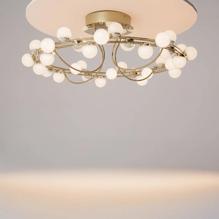 Plafonnier tessara led avec cadre métal doré disque doré et globes givrés en design organique contemporain
