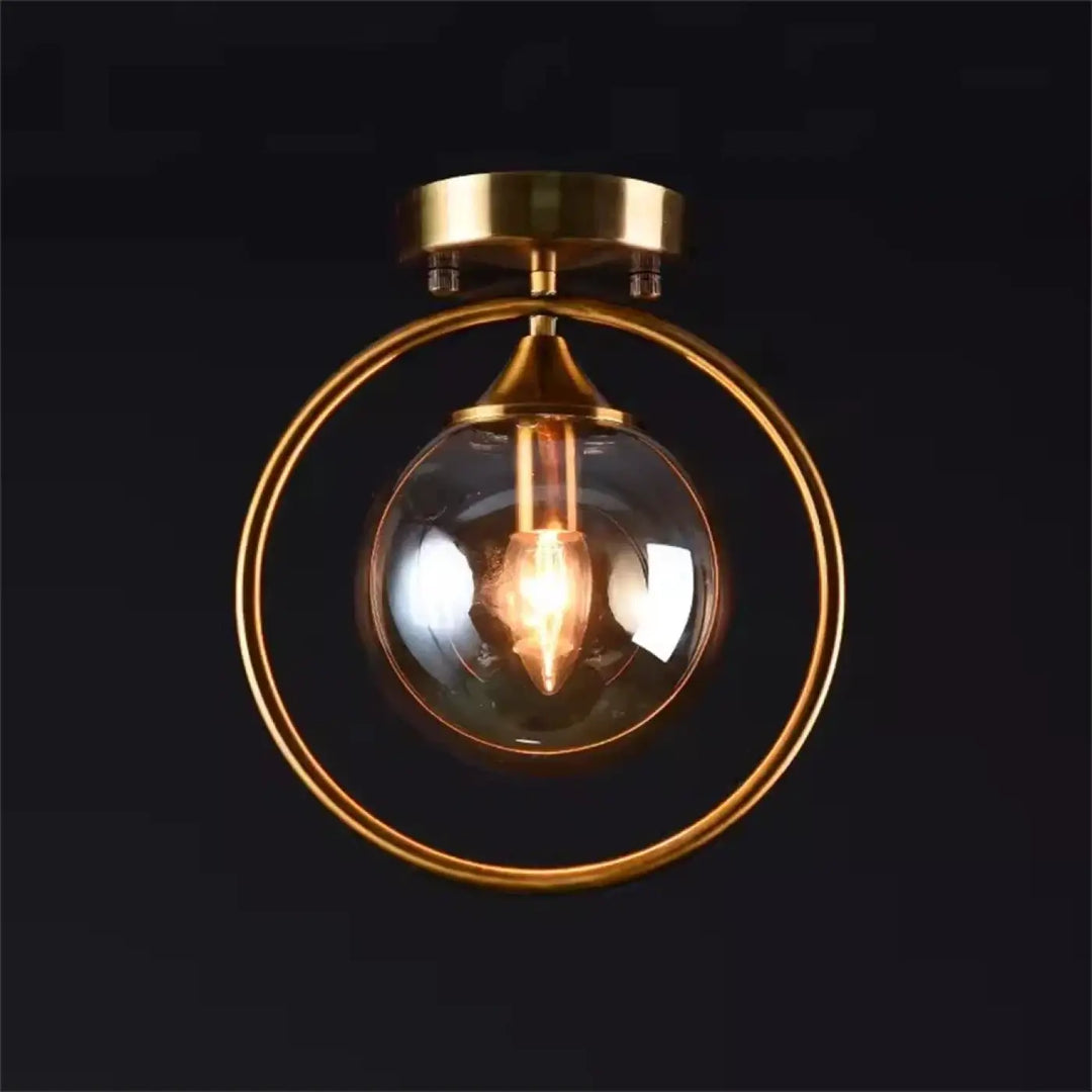 Luminaire plafonnier celliah en laiton avec globe en verre clair et ampoule à filament apparent