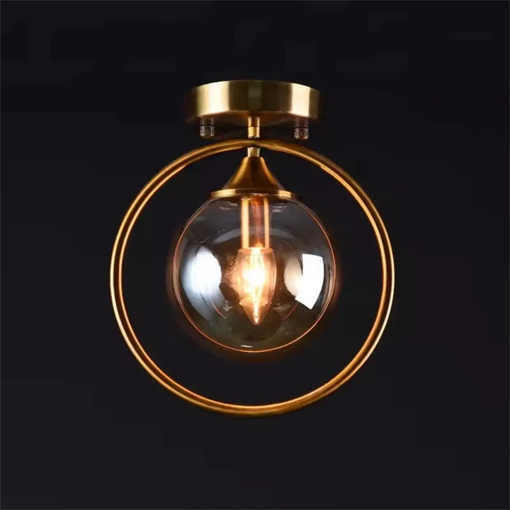 Luminaire plafonnier celliah en laiton avec globe en verre clair et ampoule à filament apparent