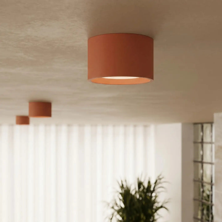 Plafonnier rond plat ocre rouge allumé, vue rapprochée