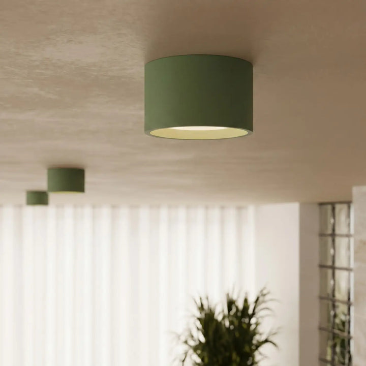 Plafonnier rond plat vert olive allumé, vue rapprochée
