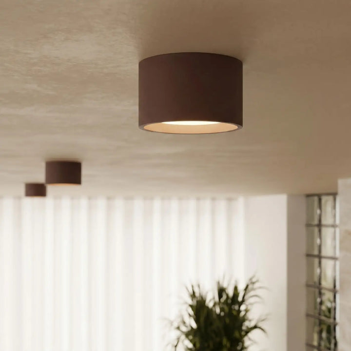 Plafonnier rond plat marron allumé, vue rapprochée