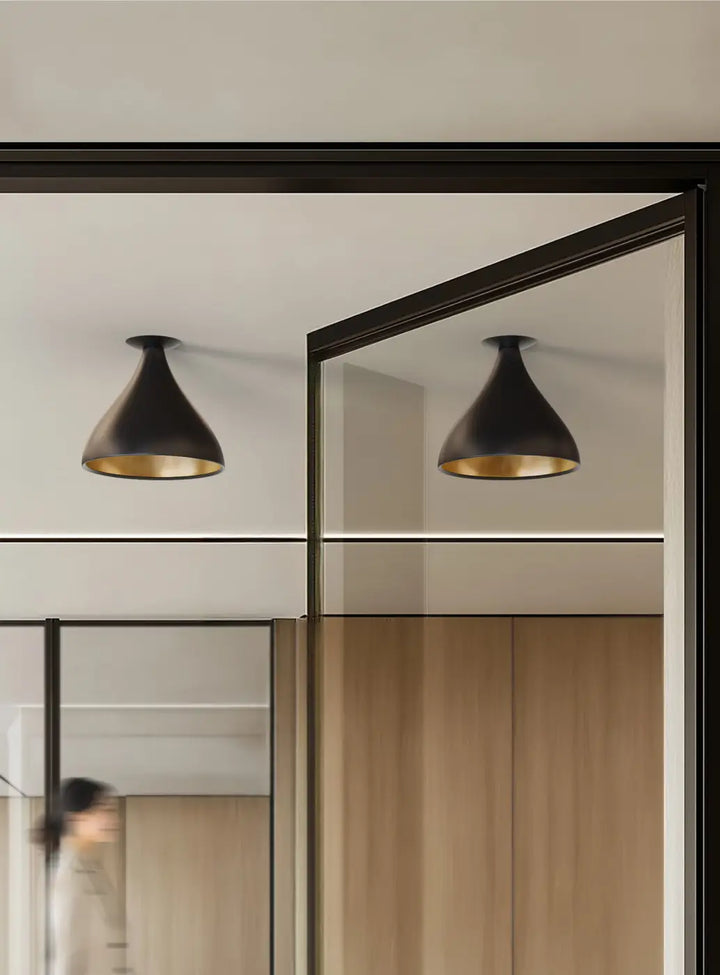Plafonnier Swell forme moyenne XL, extérieur noir et intérieur laiton dans un intérieur