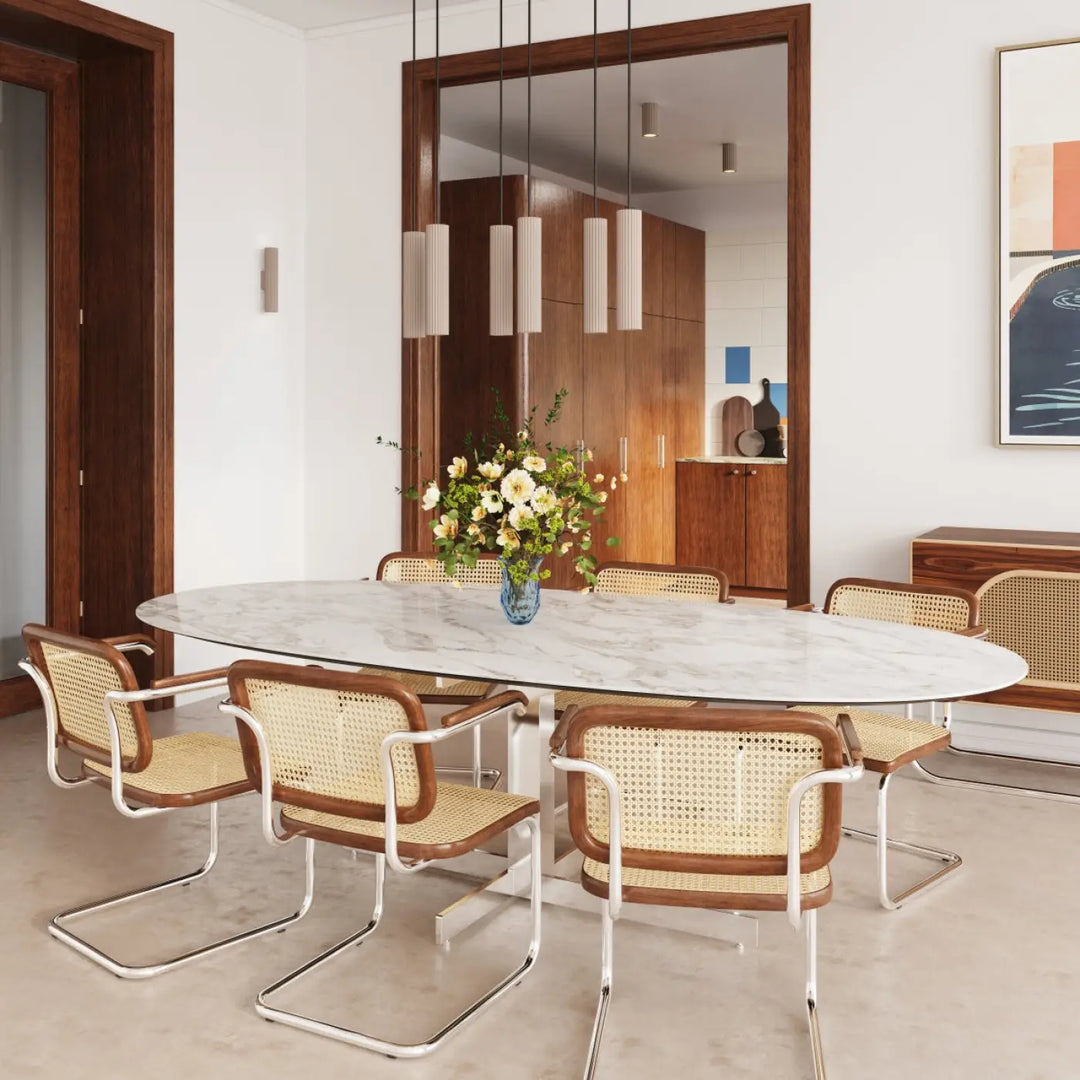 Table à manger ovale en marbre blanc avec pieds chrome et vase central de fleurs jaunes abat-jour modernes rainurés design expressif confort d’utilisation luminaire plafonnier ivar taupe led 4000k