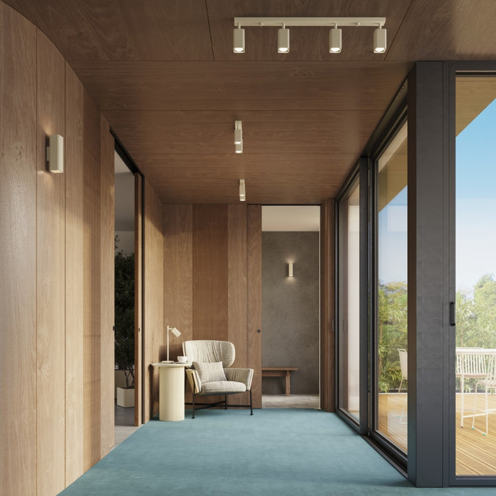 Plafonnier Rayo beige en rampe à spots orientables au plafond d'un couloir