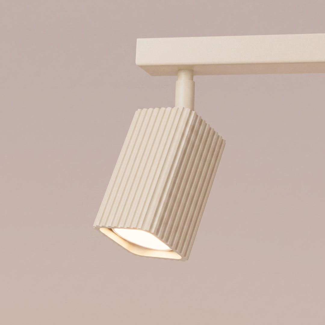 Plafonnier Rayo beige en rampe à spots orientables, détail des cannelures