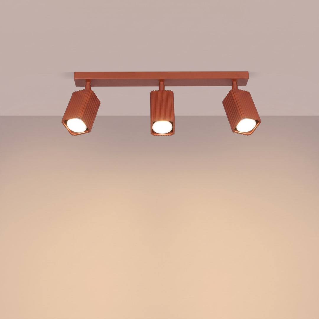 Plafonnier Rayo ocre rouge en rampe à spots orientables, allumé
