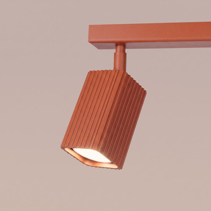 Plafonnier Rayo ocre rouge en rampe à spots orientables, détail des cannelures