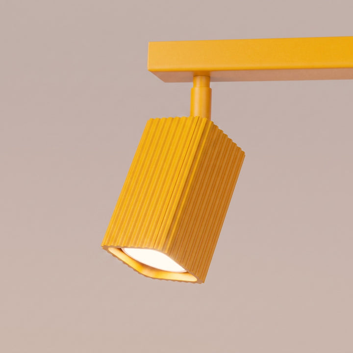Plafonnier Rayo jaune en rampe à spots orientables, détail des cannelures