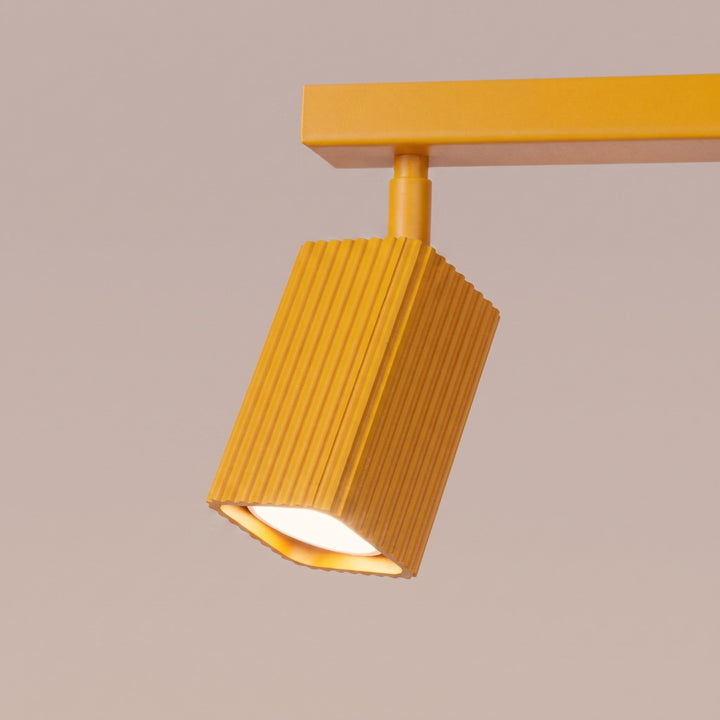 Plafonnier Rayo jaune en rampe à spots orientables, détail des cannelures