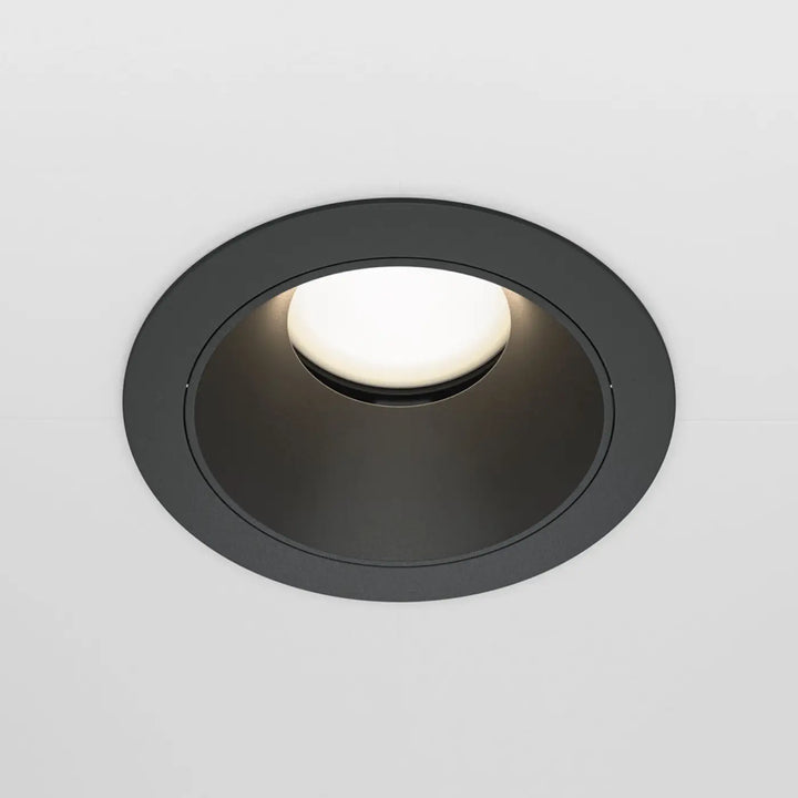 Spot encastré avec enjoliveur noir mat circulaire et centre lumineux blanc chaud culot gu10