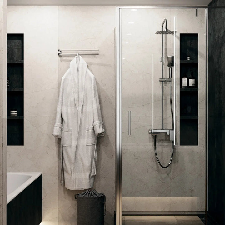 A plush white bathrobe made of soft fabric hanging on a sleek acier blanc rack from spot stockton trois formats