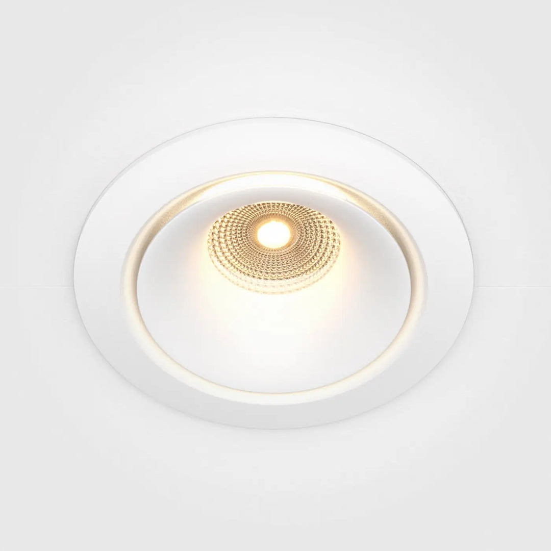 Spot yin led intégrée blanc chaud avec centre circulaire texturé doré émettant une lumière chaleureuse encastrée