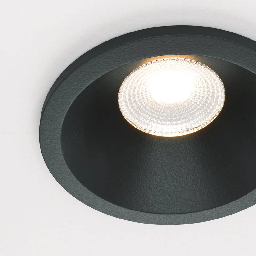 Spot led encastré zoom avec cadre texturé noir et lentille en verre facetté émettant un blanc chaud indice ip65