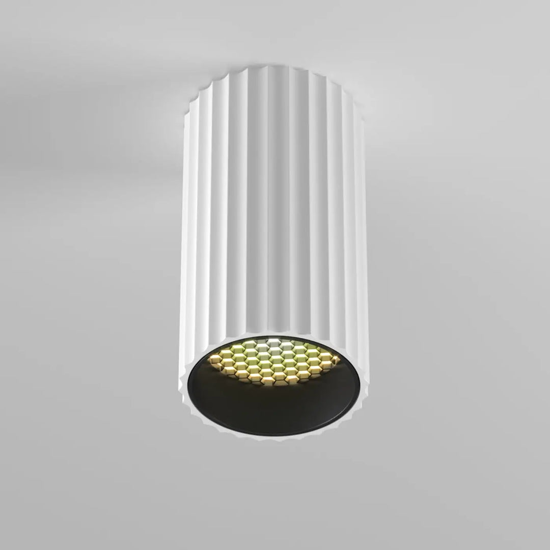 Spot calipso cylindre cannelé blanc avec éclairage ciblé led hexagonal doré sur base noire trois finitions disponibles