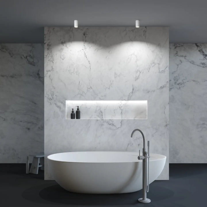 Baignoire blanche autoportante spot zoom avec design moderne arrondi sous faux plafond avec lumière dirigée