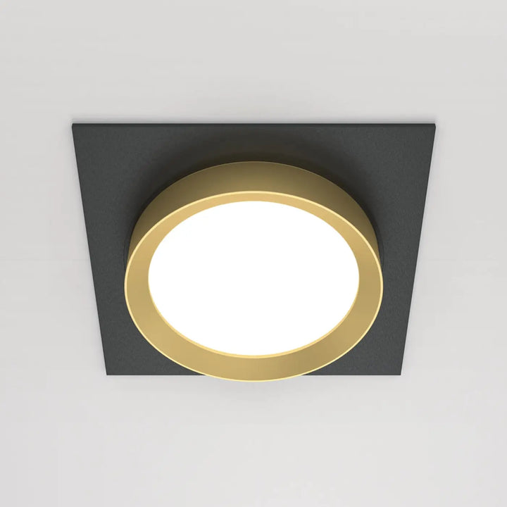 Spot semi-encastré cadre carré avec cadre noir et disque lumineux or entourant centre blanc lumineux