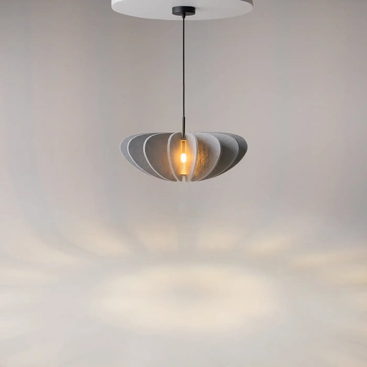 Suspension luminaire cambio avec design superposé en aluminium noir translucide diffusant une lumière chaude au-dessus d’une table