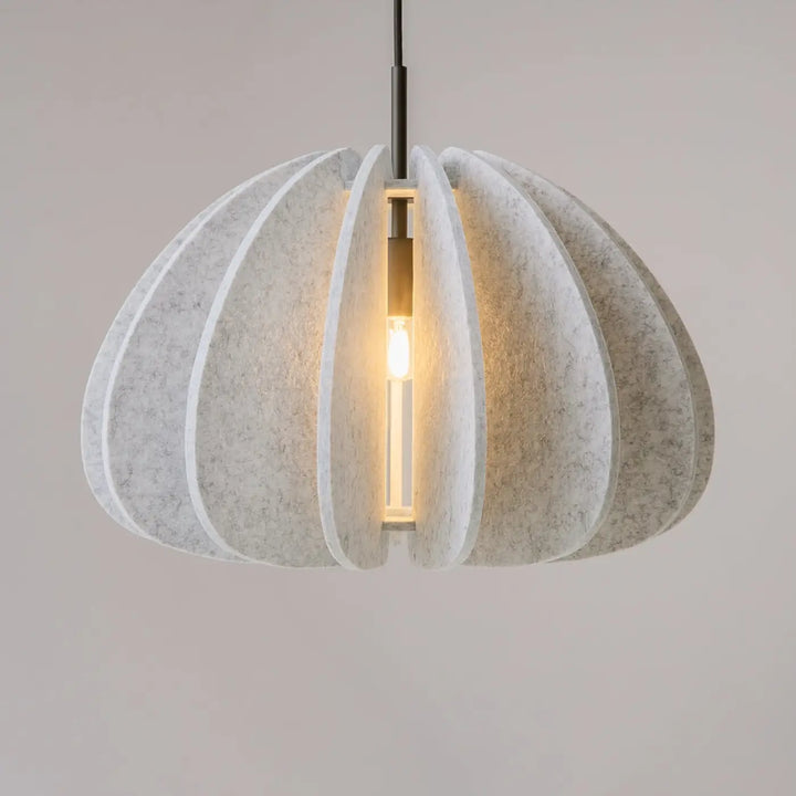 Suspension luminaire cambio avec abat-jour en feutre off-white à panneaux incurvés superposés au-dessus d’une table