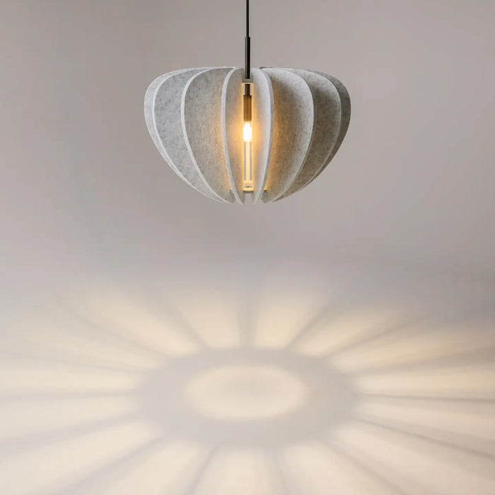 Suspension luminaire cambio coupole en béton texturé ivoire avec ampoule chaude pour éclairer au-dessus d’une table
