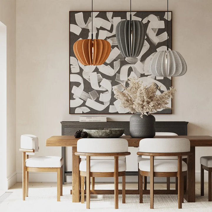 Suspension luminaire cambio coupole en aluminium noir suspendue au-dessus d’une table en bois avec chaises blanches et vase gris