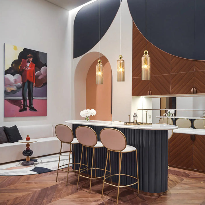 Suspension luminaire antic avec monture dorée et abat-jour étroit en verre strié suspendue au-dessus d’un bar