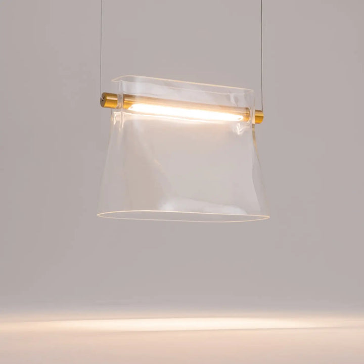 Suspension cabaret en verre transparent avec fixations dorées pour éclairage au-dessus d’une table moderne