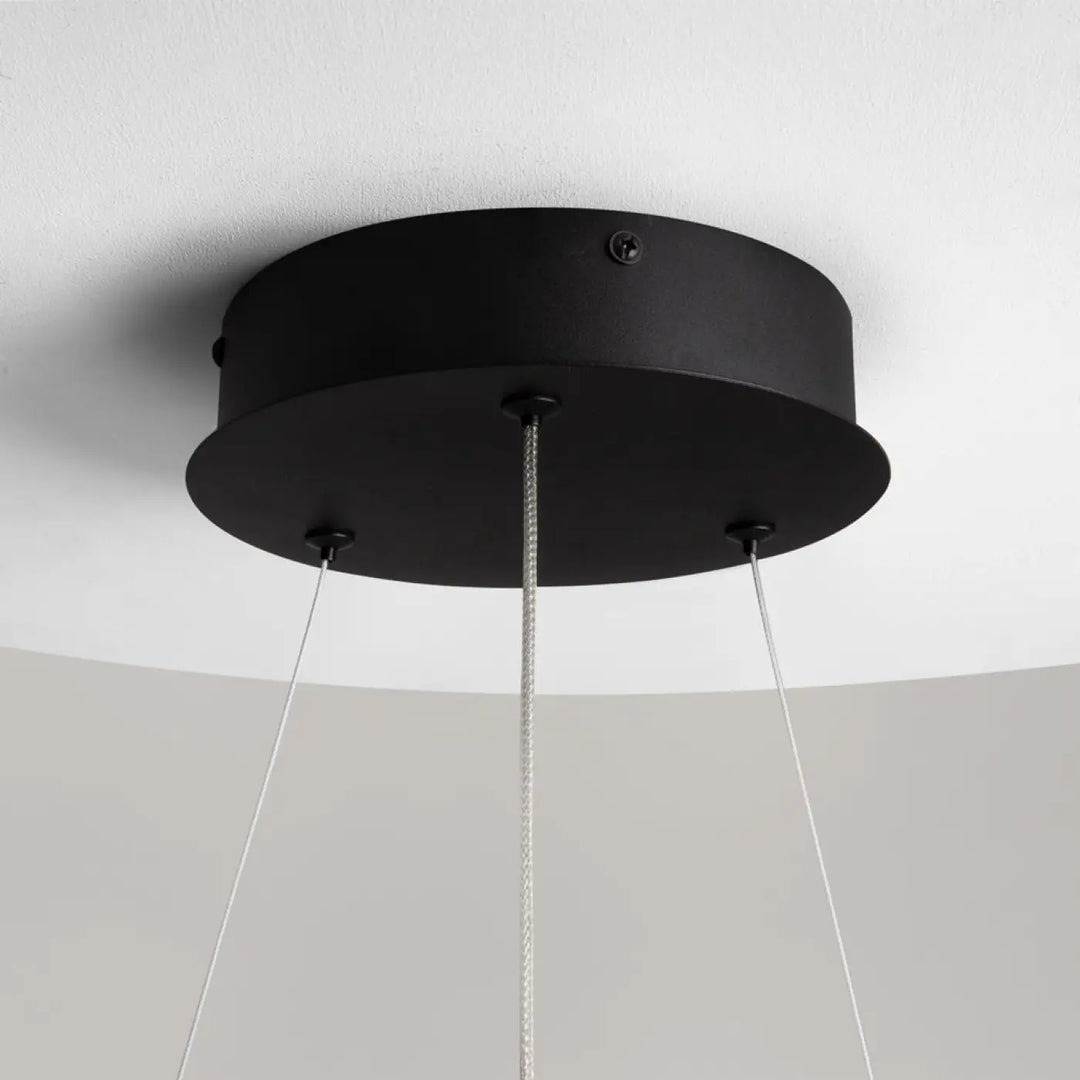Suspension curve anneau ondulé en aluminium noir avec fixation plafond circulaire et trois câbles fins descendent