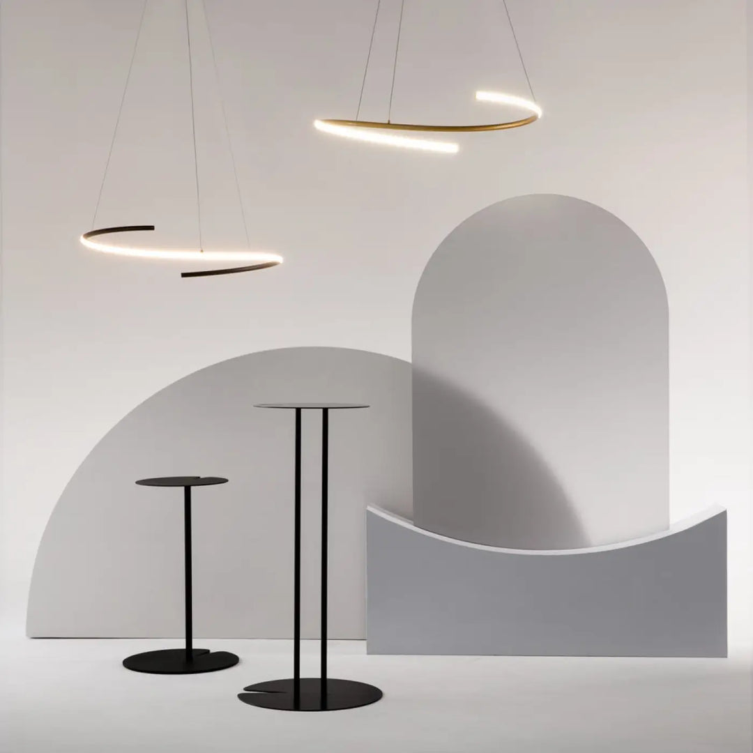 Minimalist black metal cocktail tables with sleek circular tops and slender legs complement aluminium noir suspension curve anneau ondulé design