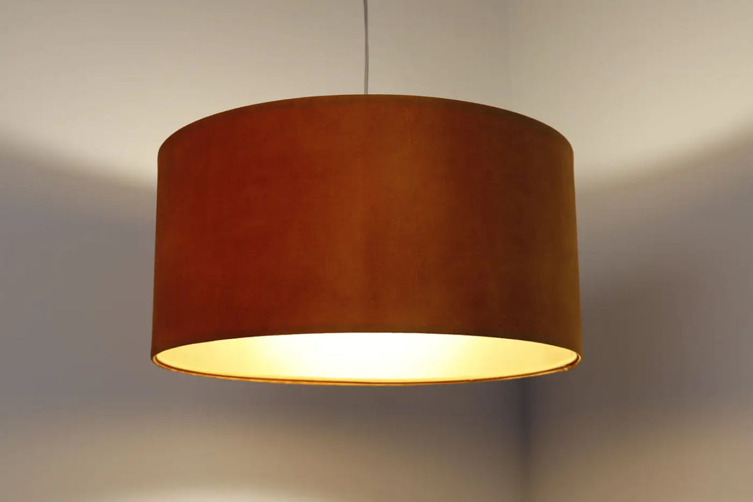 Suspension design dorée en velours ambré warm avec abat-jour textile et matières naturelles au doux éclat intérieur