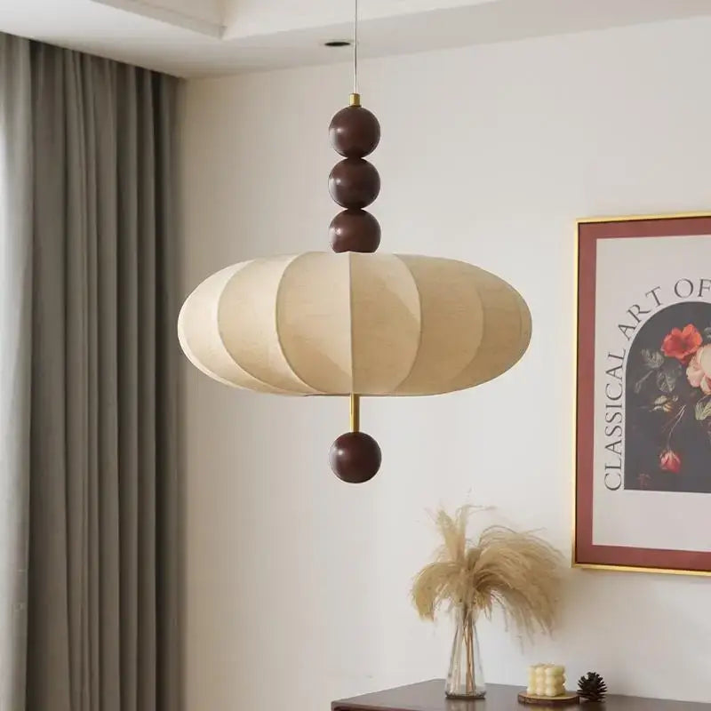 Suspension design en tissu beige et boules de bois modernes

