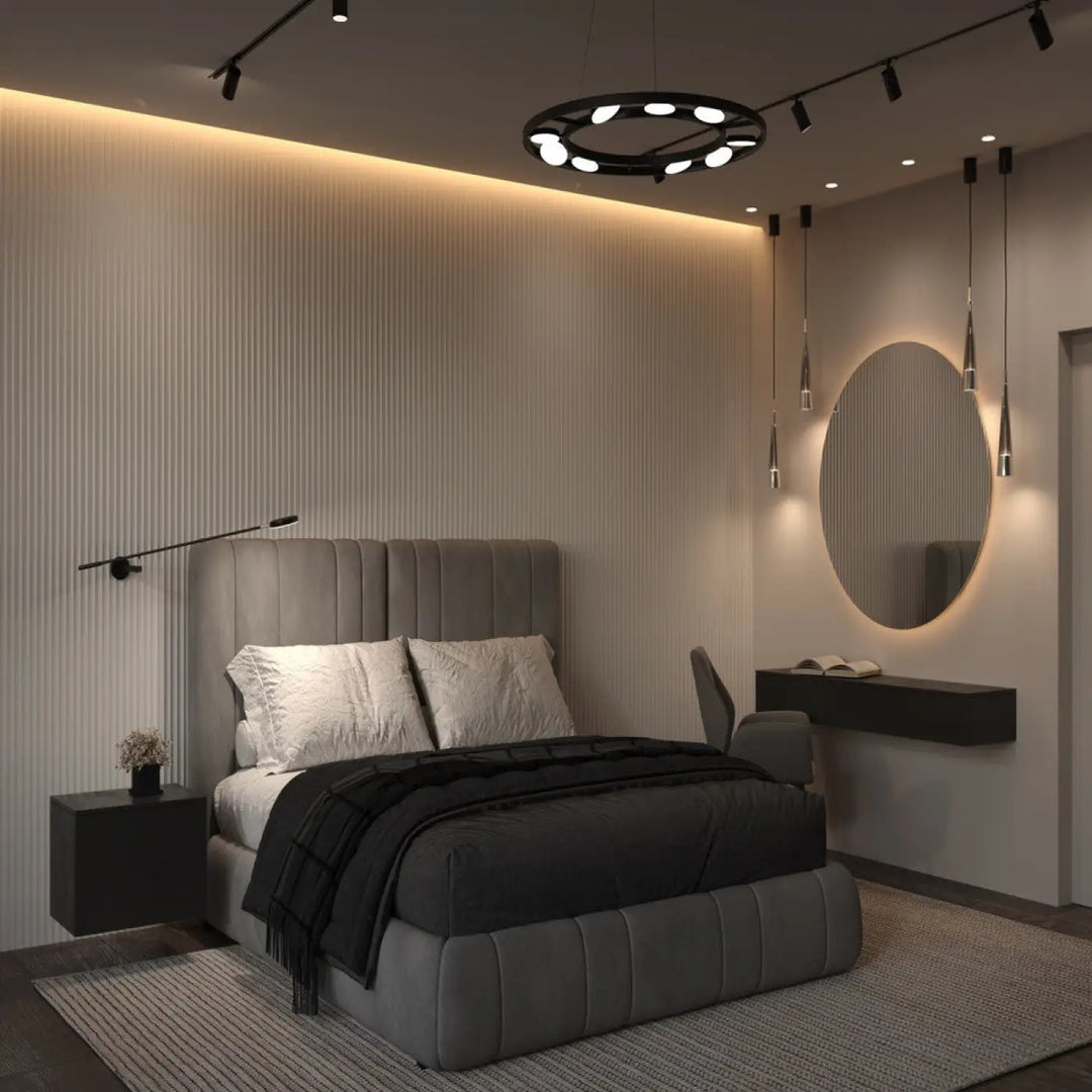 Lit tufté gris avec literie noire et oreillers blancs sous une suspension fad métal noir avec spots articulés