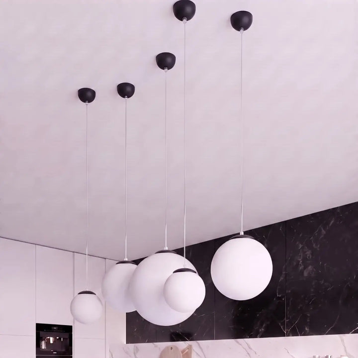 Suspension Ugo à globe en verre blanc et monture noire dans un intérieur contemporain