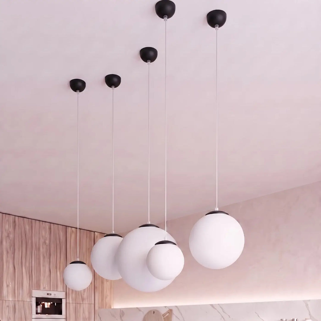 Suspension Ugo à globe en verre blanc et monture noire dans un intérieur contemporain