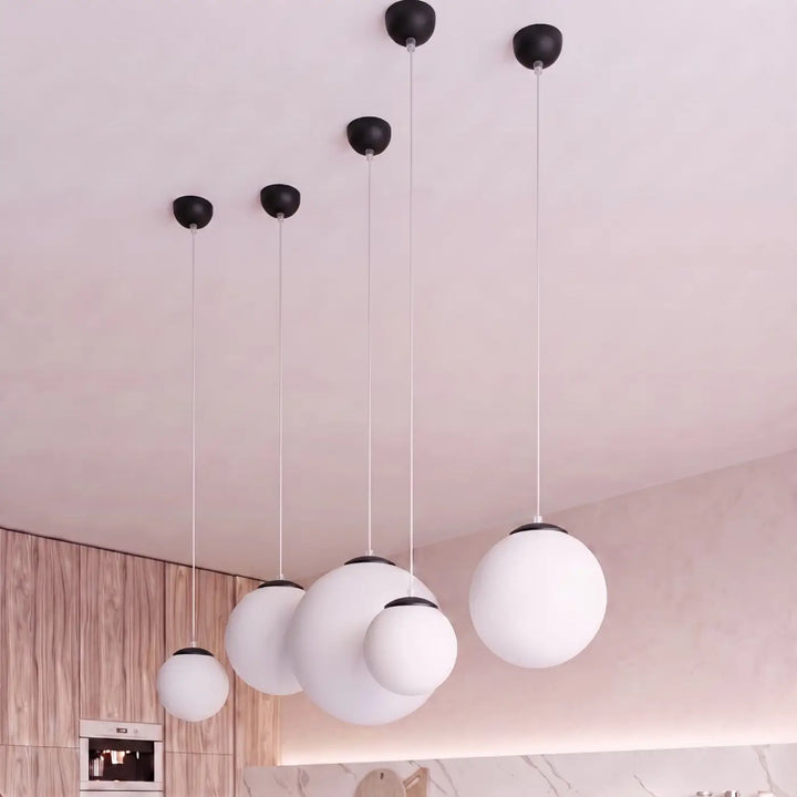 Suspension Ugo à globe en verre blanc et monture noire dans un intérieur contemporain