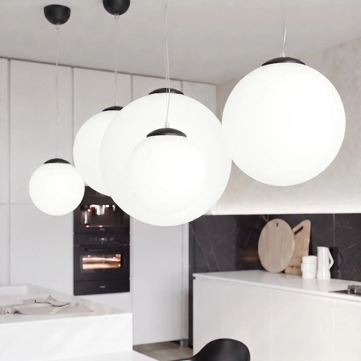 Suspension Ugo à globe en verre blanc et monture noire dans un intérieur contemporain