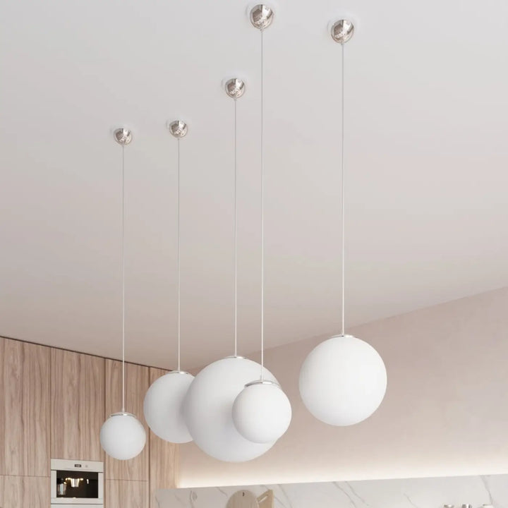 Suspension Ugo à globe en verre blanc et monture chromée dans un intérieur contemporain