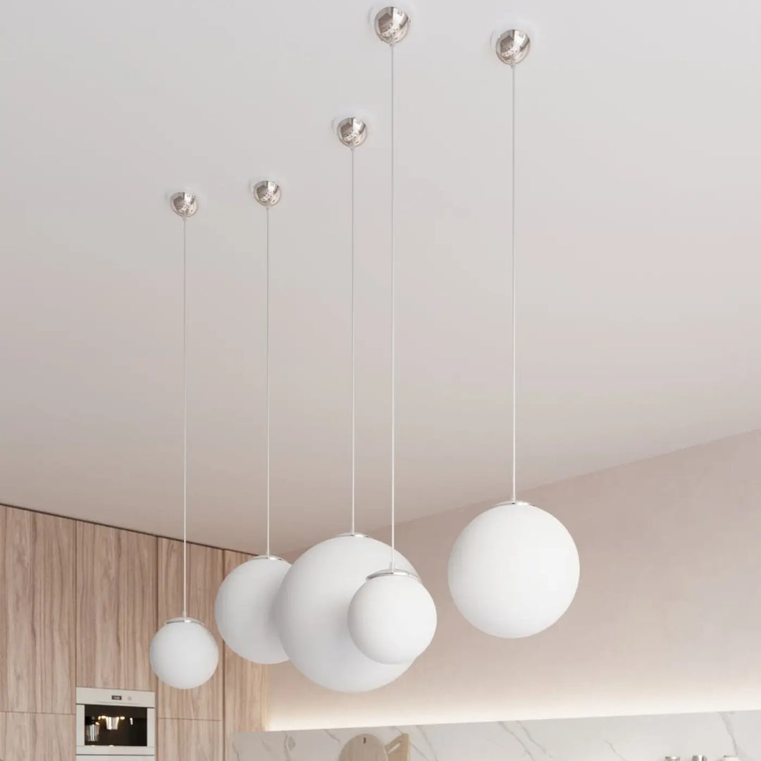Suspension Ugo à globe en verre blanc et monture chromée dans un intérieur contemporain