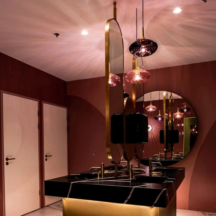 Miroir ovale suspendu grace avec cadre doré et verre soufflé pour un modèle grace élégant et moderne