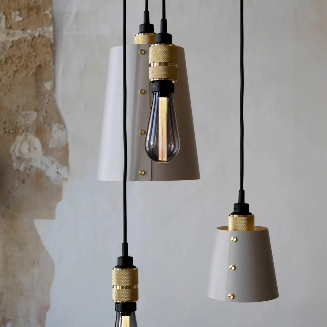 Suspension Hooked 6.0 à abat-jour coloris pierre, finition laiton, dans un intérieur #couleur_dor