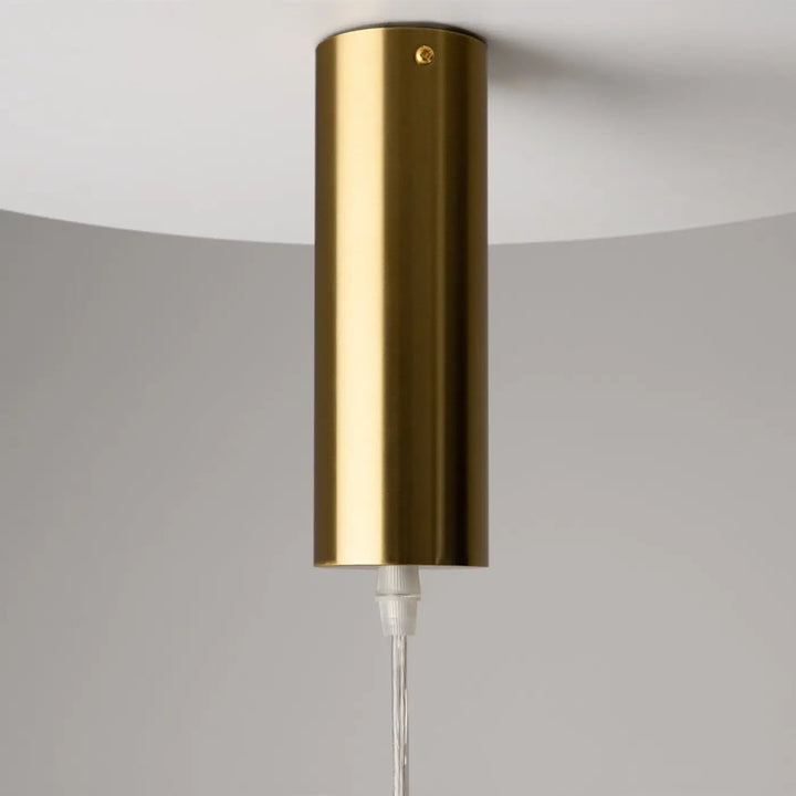 Suspension luminaire sonata cylindre en acier doré avec design minimaliste et suspension led au-dessus d’un îlot