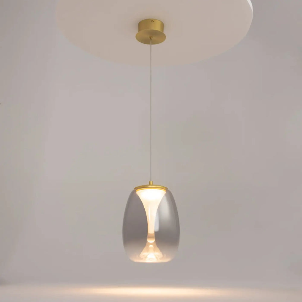 Suspension luminaire splash led avec abat-jour en verre translucide et accents métalliques dorés au-dessus d’un îlot