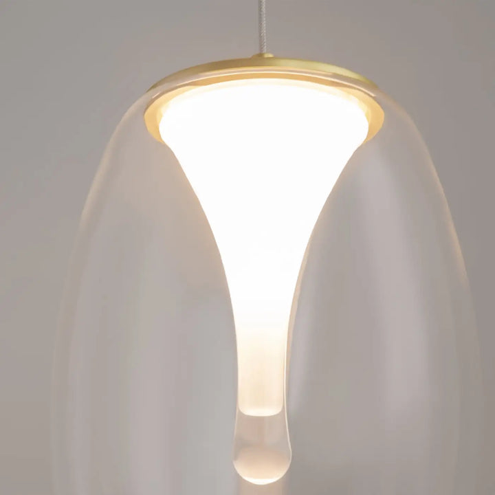 Suspension led splash avec abat-jour en verre translucide en forme de goutte orné de métal doré au-dessus d’un îlot