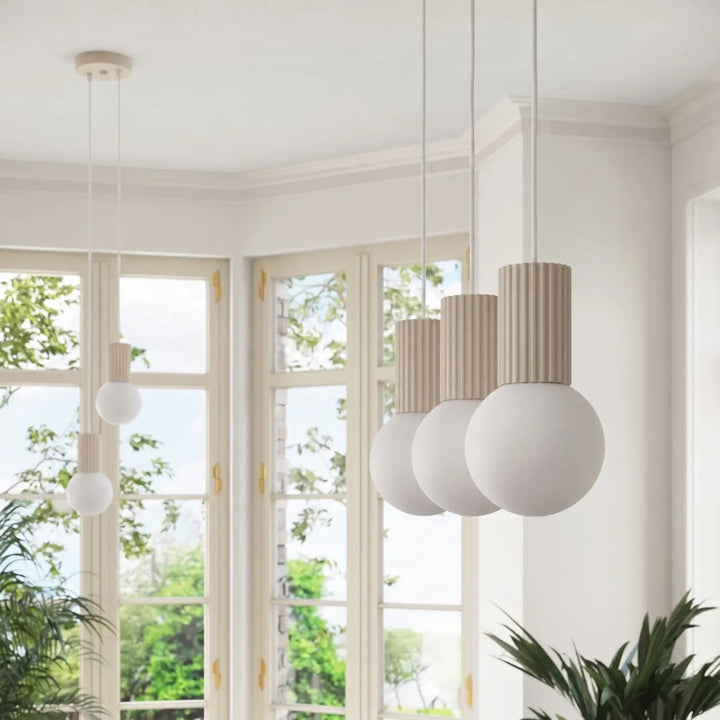 Suspension Halo beige en ligne à globes opalins, allumée