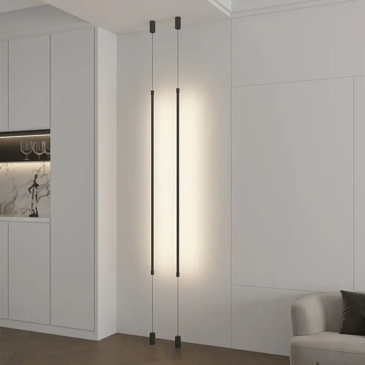 Suspension luminaire attachée au plafond au sol par une barre LED
