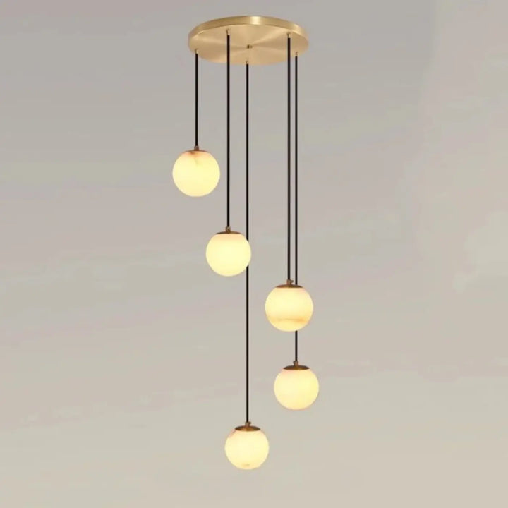 Suspension luminaire souble en laiton moderne avec cinq boules en verre marbré chic suspendues par cordons noirs univers art déco