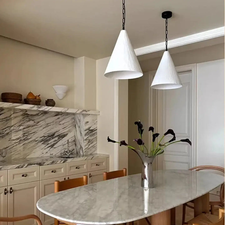 Suspension luminaire halia avec luminaire conique design blanc suspendu par chaîne noire au-dessus de la table à manger