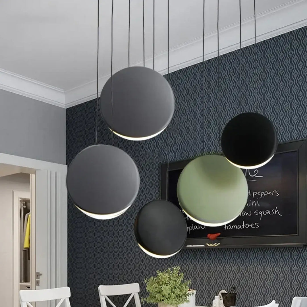 Suspension luminaire lunis avec abat-jours circulaires en vert mat et noir mat suspendus par câbles fins minimalistes