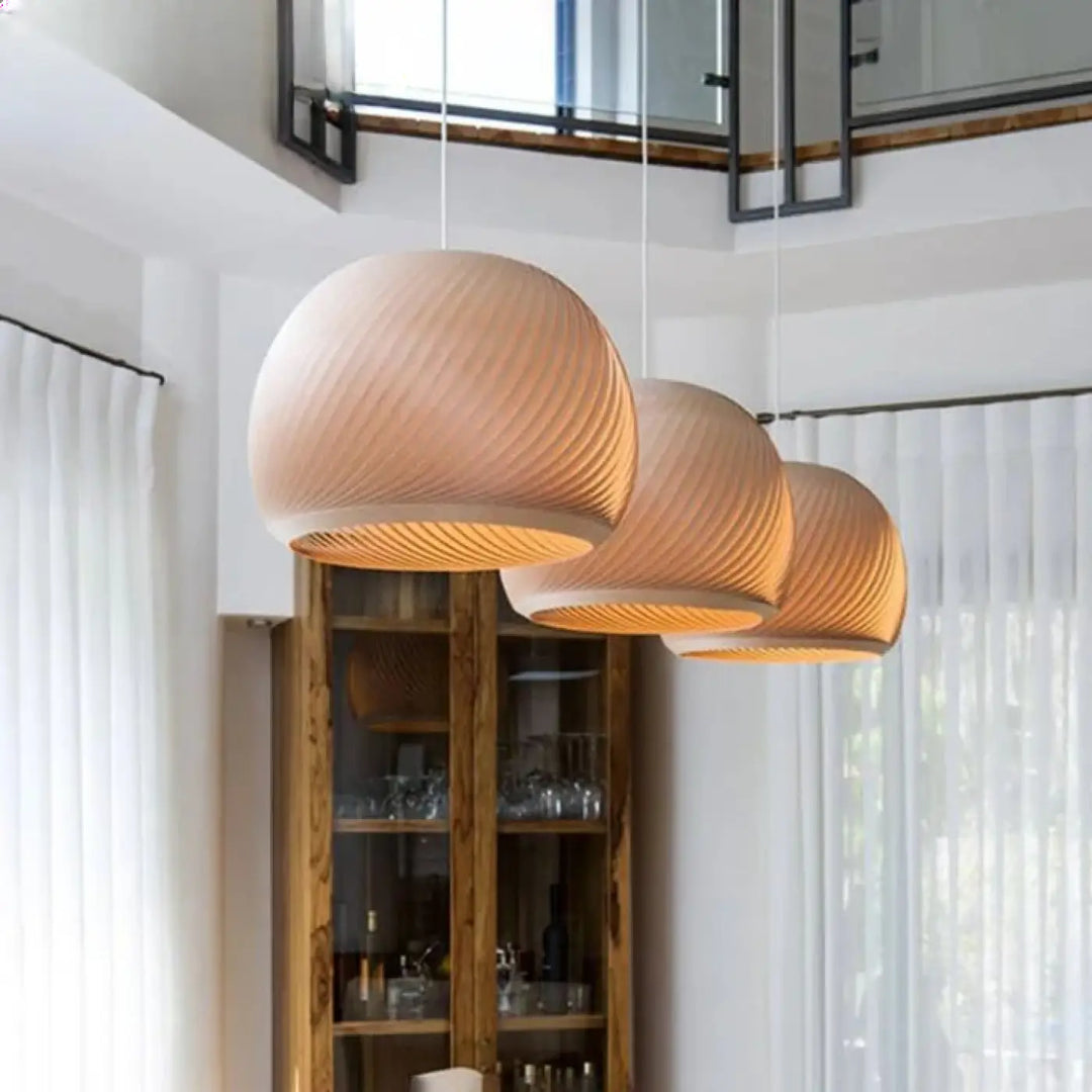 Three warm-toned ribbed wooden suspension luminaires with bois aux formes design in a modern interior