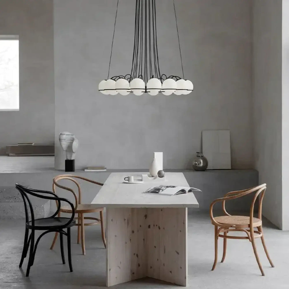 Suspension luminaire cloudis avec plusieurs globes sphériques blancs suspendus par cordons noirs et structure métallique centrale